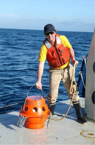Figure 7.  The author, Kevin Hardy, lifts the single sphere hadal lander, DOV Mary Carol, with one hand onto the ship after a test dive off San Diego in 2002.  DOV Mary Carol later dove both the Puerto Rico Trench and Aleutian Trench.  (Photo by Dr. Art Yayanos, Scripps Institution of Oceanography/UCSD)