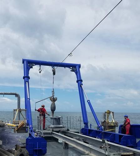 Figure 2 – The piston coring rig deployed over the stern, and just prior to sampling. Image courtesy of A. Evans.