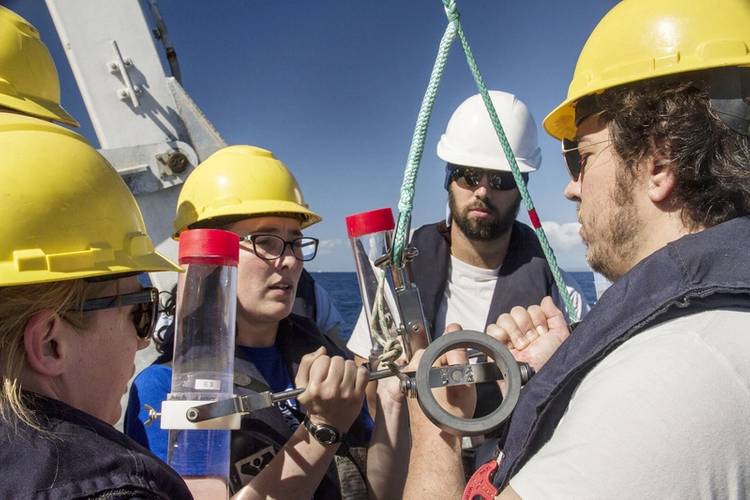 Melissa Omand, Phillipp Gunther, Colleen Durkin and Ben Knorlein make sure that the sediment trap is ready and steady as they deploy it off of Falkor’s aft deck. (Photo: SOI/ Mónika Naranjo González)
