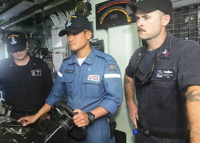 Petty Officer Third Class Higuchi Shoma, Japanese Maritime Self Defense Force (JMSDF), center, pilots USS Pioneer during 2JA 2017 Mine Countermeasures Exercise (2JA-17 MCMEX) as Mineman First Class Zachary Abel, right, observes. 2JA Mine Countermeasures Exercise is an annual bilateral exercise held between the U.S. Navy and JMSDF to strengthen interoperability and increase proficiencies in mine countermeasure operations. (Photo by William McCann)