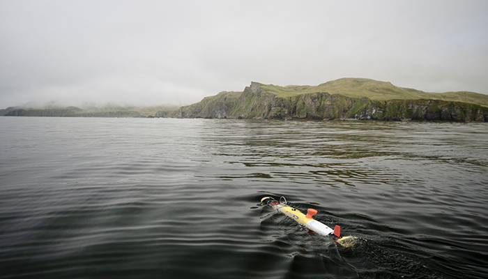 A REMUS 100 autonomous underwater vehicle (ocean glider) departs a research boat before diving beneath the surface where it spent the next six hours systematically scanning the seafloor in search of sunken vessels from World War II. (Courtesy of Project Recover)