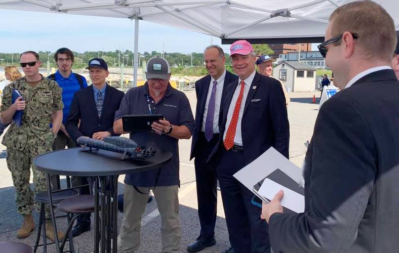 Rhode Island Secretary of Commerce Stefan Pryor (center, from left) and U.S. Sen. Sheldon Whitehouse get a demo on the latest swarming technology from Aquabotix during the Advanced Naval Technology Exercise (ANTX) 2019 held on Aug. 29 at the Naval Undersea Warfare Center Division Newport. (by Public Affairs Officer Jeff Prater)