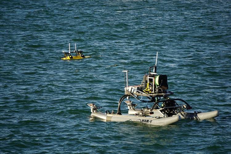 A Seabotix ROV is lowered into the water from a WAM-V, with a Z-Boat 1800RP nearby (Photo: Eric Haun)