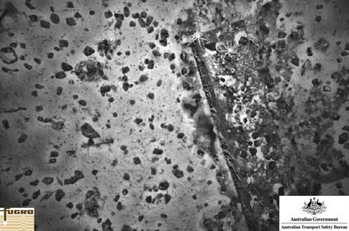 Ship-related debris on the sea floor. White sea stars can be seen on some of the debris while the black objects are believed to be lumps of coal (Source: ATSB, photo by Fugro)