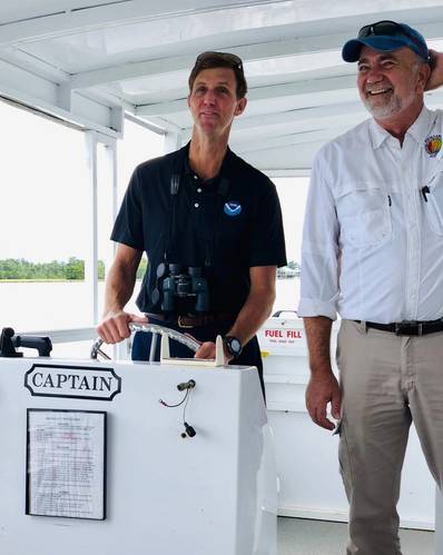 Taking the Helm: Retired Navy Rear Admiral and Deputy NOAA administrator Tim Gallaudet takes the vessel’s wheel during an August 2019 tour of the Weeks Bay  National Estuarine Research Reserve in Alabama, with Eric Brunden, the stewardship coordinator for the reserve.
Photo: NOAA