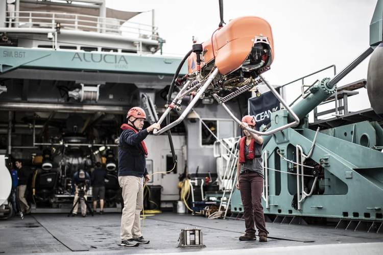 WHOI’s Tim Shank and Molly Curran position AUV Orpheus on deck for deployment operations. Image from Woods Hole Oceanographic Institution