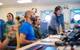 In the Computer Electronics Lab on board Research Vessel Falkor (too), the science team assembles to see the CTD data during the initial deployment of the CTD rosette. "CTD" stands for conductivity, temperature, and depth, and refers to a package of electronic devices used to detect how the conductivity and temperature of water changes relative to depth.
Credit: Alex Ingle / Schmidt Ocean Institute
