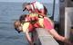 Danielle Haulsee, PhD candidate in oceanography at the University of Delaware in Lewes, and colleagues implant an acoustic receiver into a Sand Tiger shark resting in a sling. (Credit: Cara Simpson)