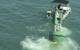 A diver boat tows a buoy with attached eco-mooring line toward divers awaiting to fasten it to one of the anchors (Photo courtesy of the U.S. Coast Guard)