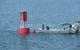 Divers prepare to go underwater for the fastening of the mooring line to its anchor (Photo courtesy of the U.S. Coast Guard)