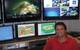 Prof. Dwight Coleman, a marine research scientist at URI’s Graduate School of Oceanography, and Director of the Inner Space Center, sits in front of a bank of monitors streaming live video feeds from remote research ships. 