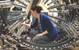 Jessica McElman, an electrical engineer at Naval Surface Warfare Center, Carderock Division, adjusts a magnetic field sensor in the model track located in the Magnetic Fields Laboratory in West Bethesda, Md. (U.S. Navy photo by Nicholas Malay)