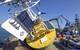 Moorings, some with large blue-and-yellow surface buoys, serve as platforms for scientific instruments and are a key component of the OOI’s arrays. Instruments are attached to the surface buoy to observe the marine atmosphere, and to the anchor frame and interconnecting cable to make measurements of the physical, chemical, and biological properties of the ocean. (Photo by Ken Kostel, Woods Hole Oceanographic Institution)