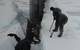 Sailors aboard the fast attack submarine USS Seawolf remove arctic ice from the hull after surfacing at the North Pole. (U.S. Navy photo)