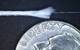 A sample of fiber optic fishing line with the inner fiber optic core exposed, next to a United States quarter for scale. The outer diameter of the fishing line is less than one millimeter. Photo courtesy of Brennan Phillips.