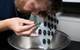 NASA scientist Dr. Marc Fries examines early sample returns attached to a magnetic board. (Photo: Susan Poulton/OET)