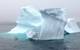 Small experimental unmanned surface craft conducting experiments near an iceberg.